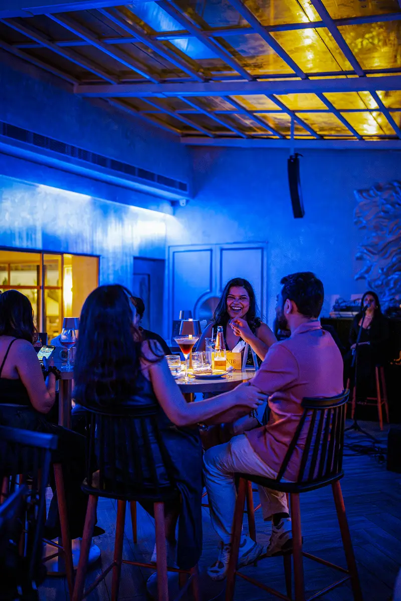Guests gathered at the bar under blue light