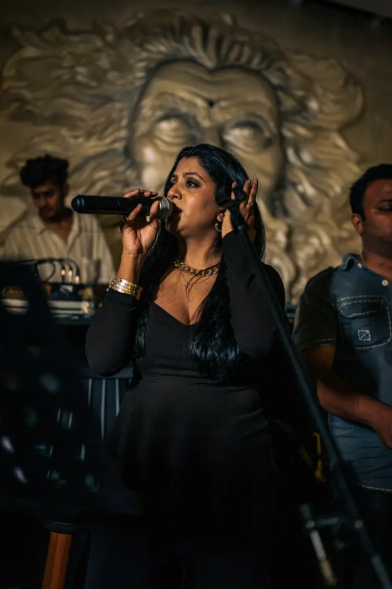 A singer performing in front of the lion-face wall